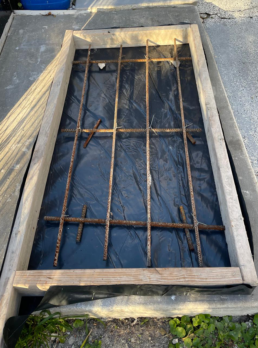 A wooden frame is sitting on top of a black tarp.