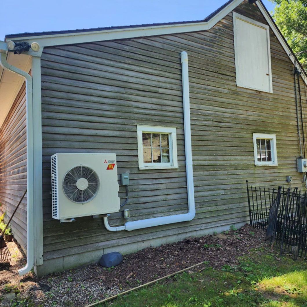 A house with a fan on the side of it.