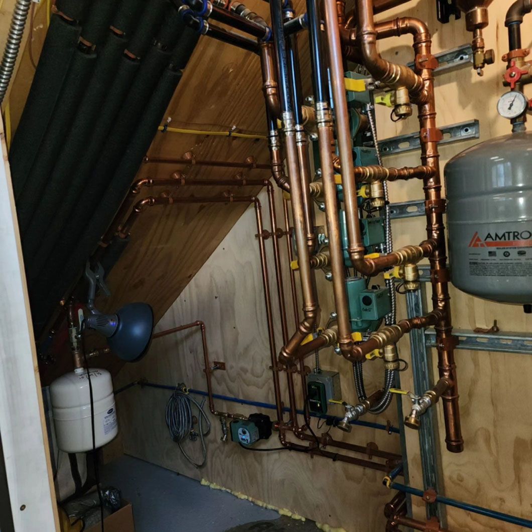 A room with copper pipes and a tank that says agro