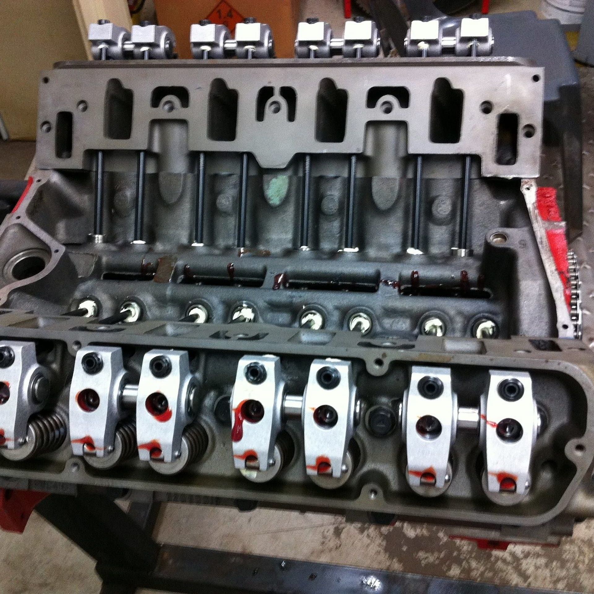 A close-up of a partially assembled V8 engine block, showing metal rocker arms, pushrods, and valve springs. — JNL Crankshaft Services in Palmerston City, NT
