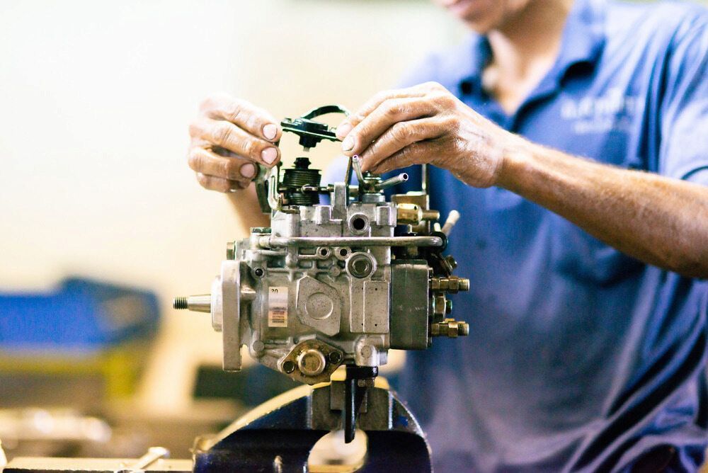 A Person in a Blue Shirt Works on a Fuel Injection Pump Mounted — JNL Crankshaft Services in Palmerston City, NT