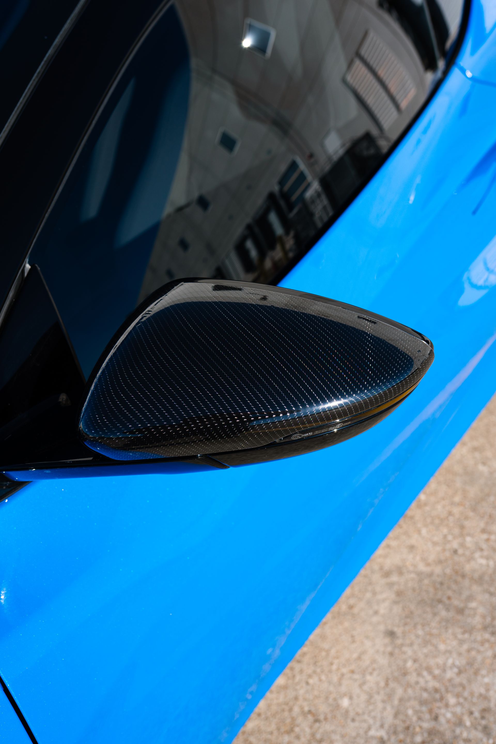 A person is applying tinted window film to a car window.