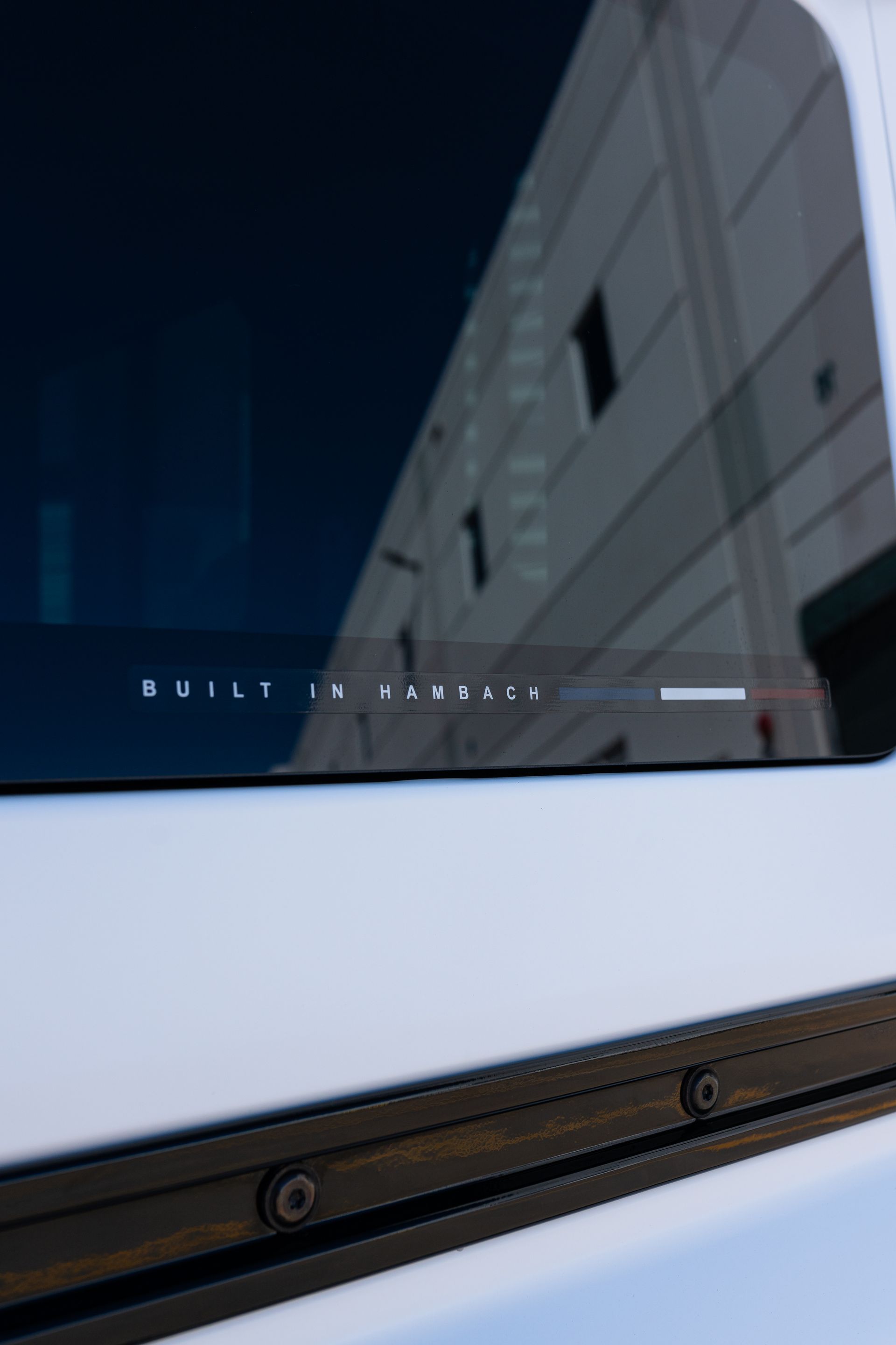 A person is applying tinted window film to a car window.