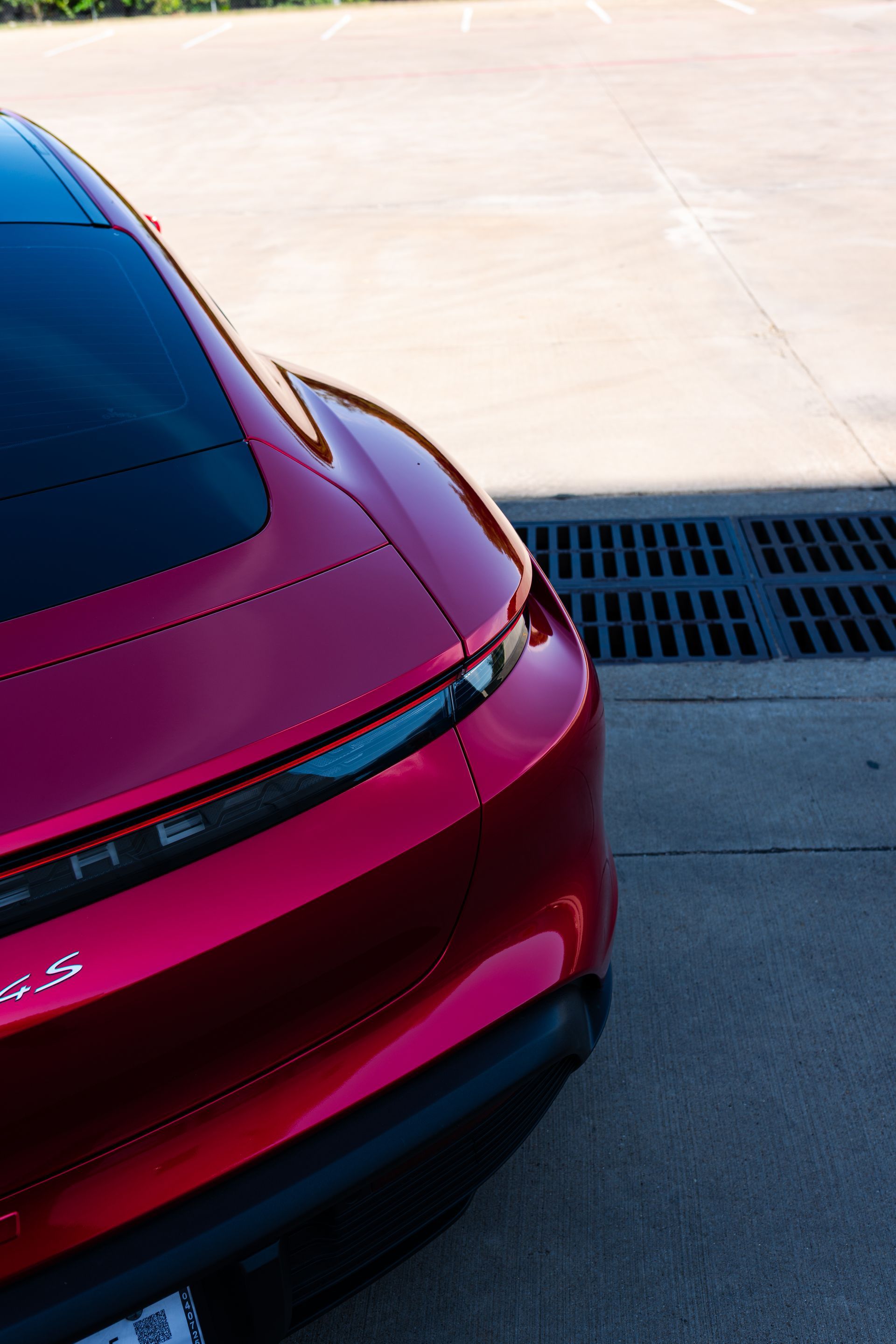 A red tesla model s is parked in a parking lot