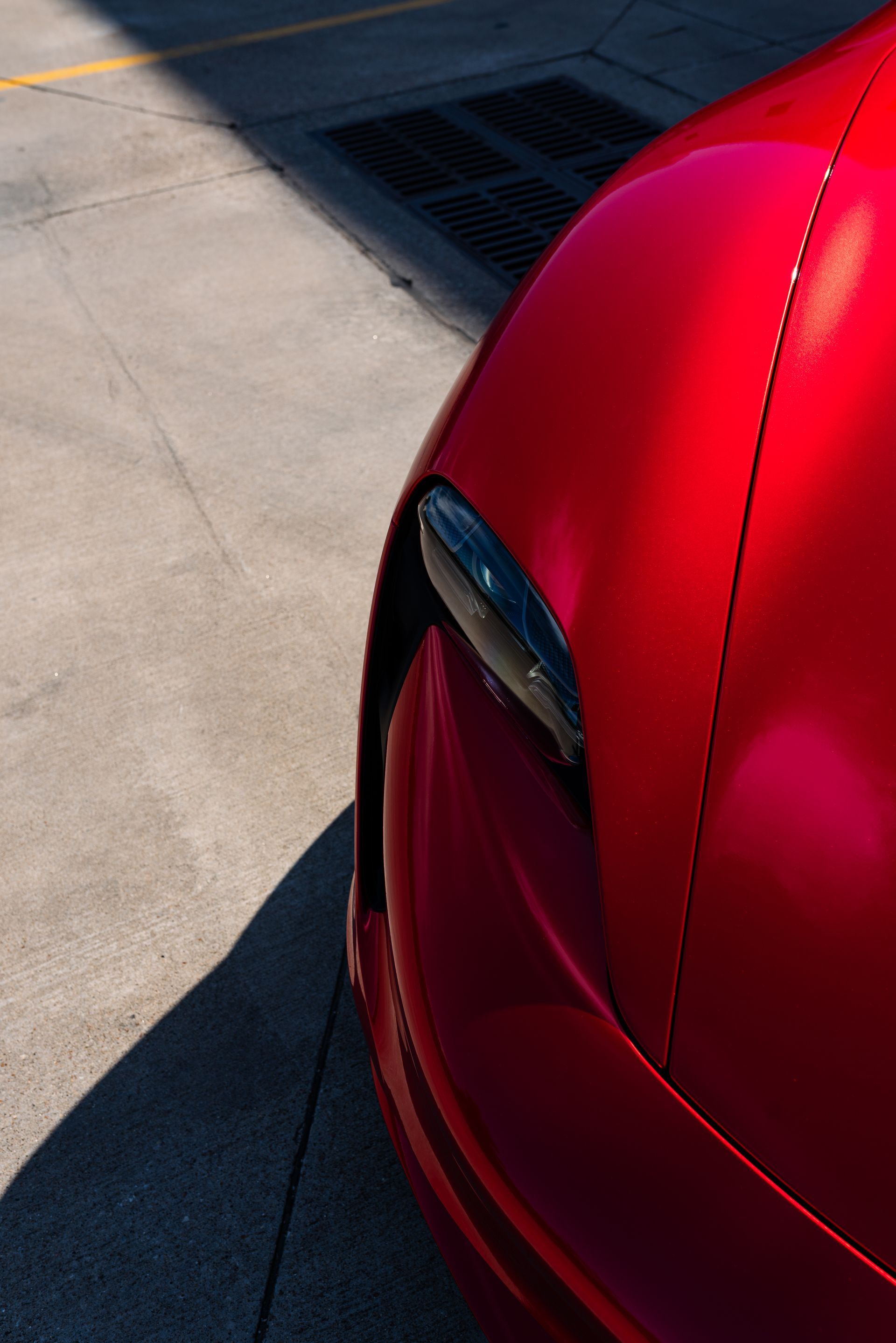 A red car is parked on the side of the road