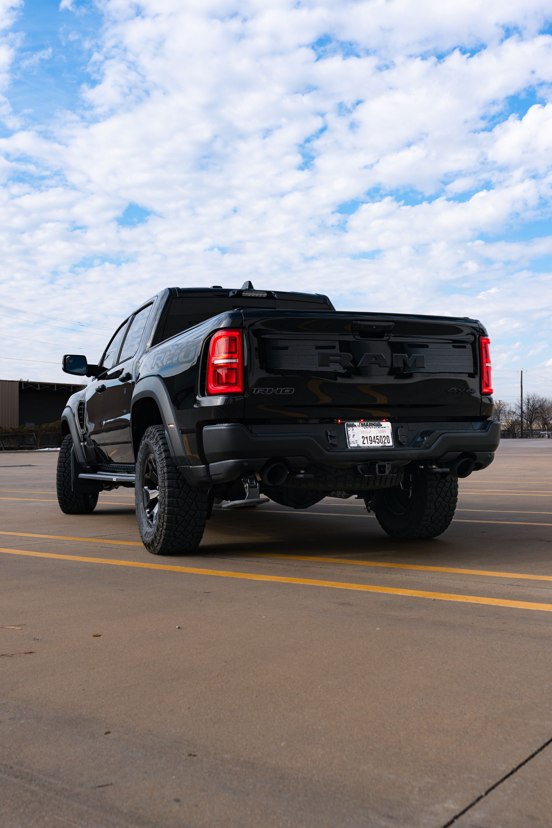 A black truck is parked in a parking lot.
