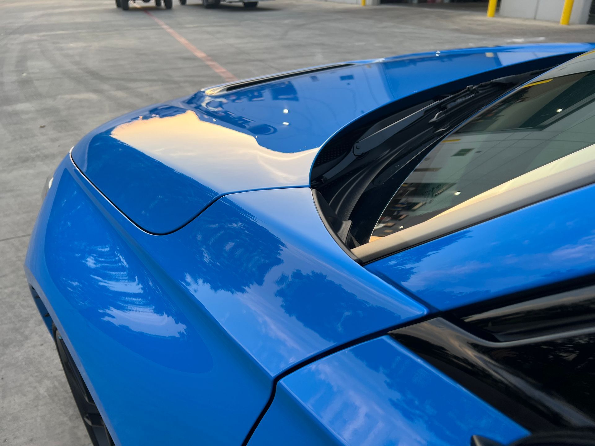 A blue car is parked in a parking lot