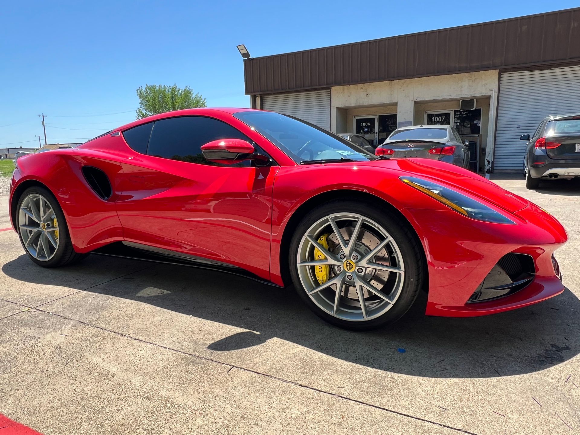 A red ferrari 488 gtb is parked in front of a building.