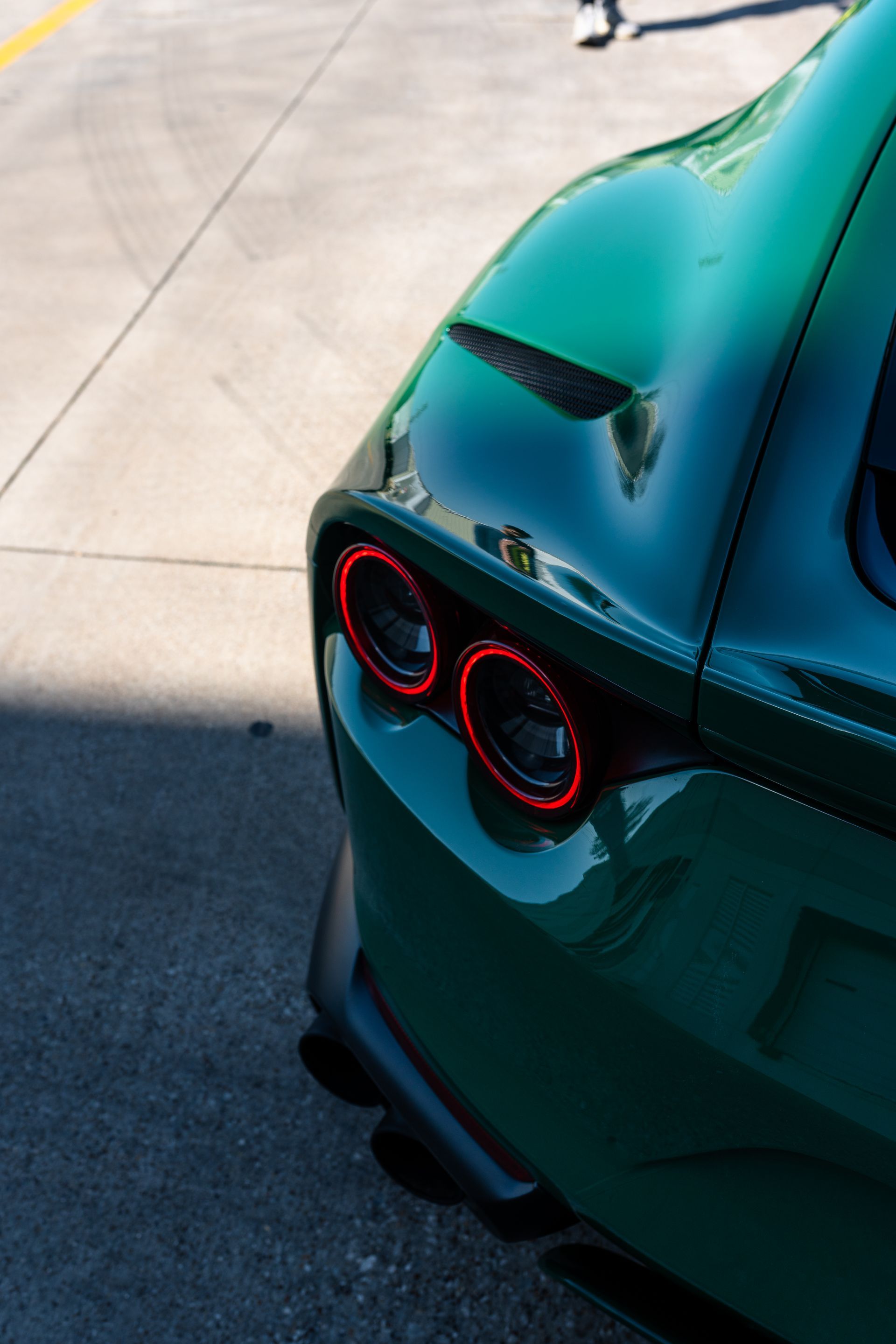 A green sports car is parked on the side of the road.