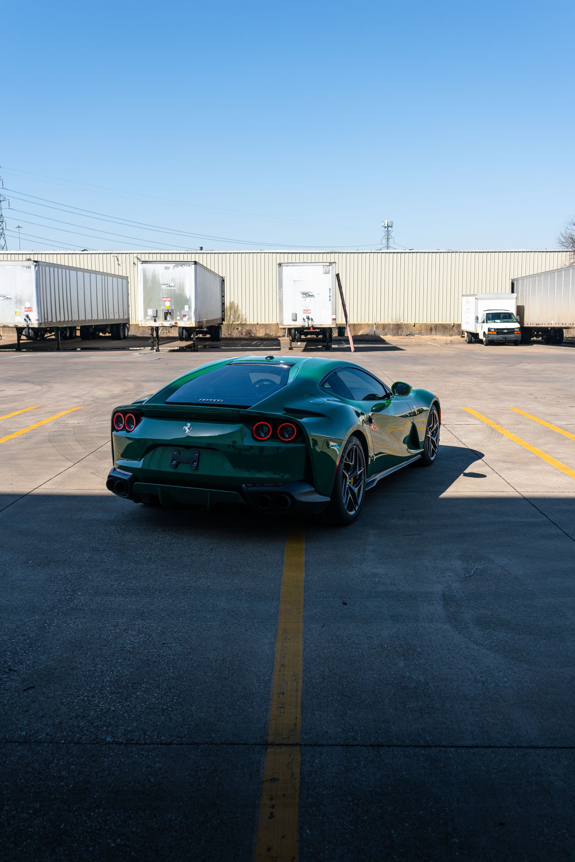 A green sports car is parked in a parking lot.