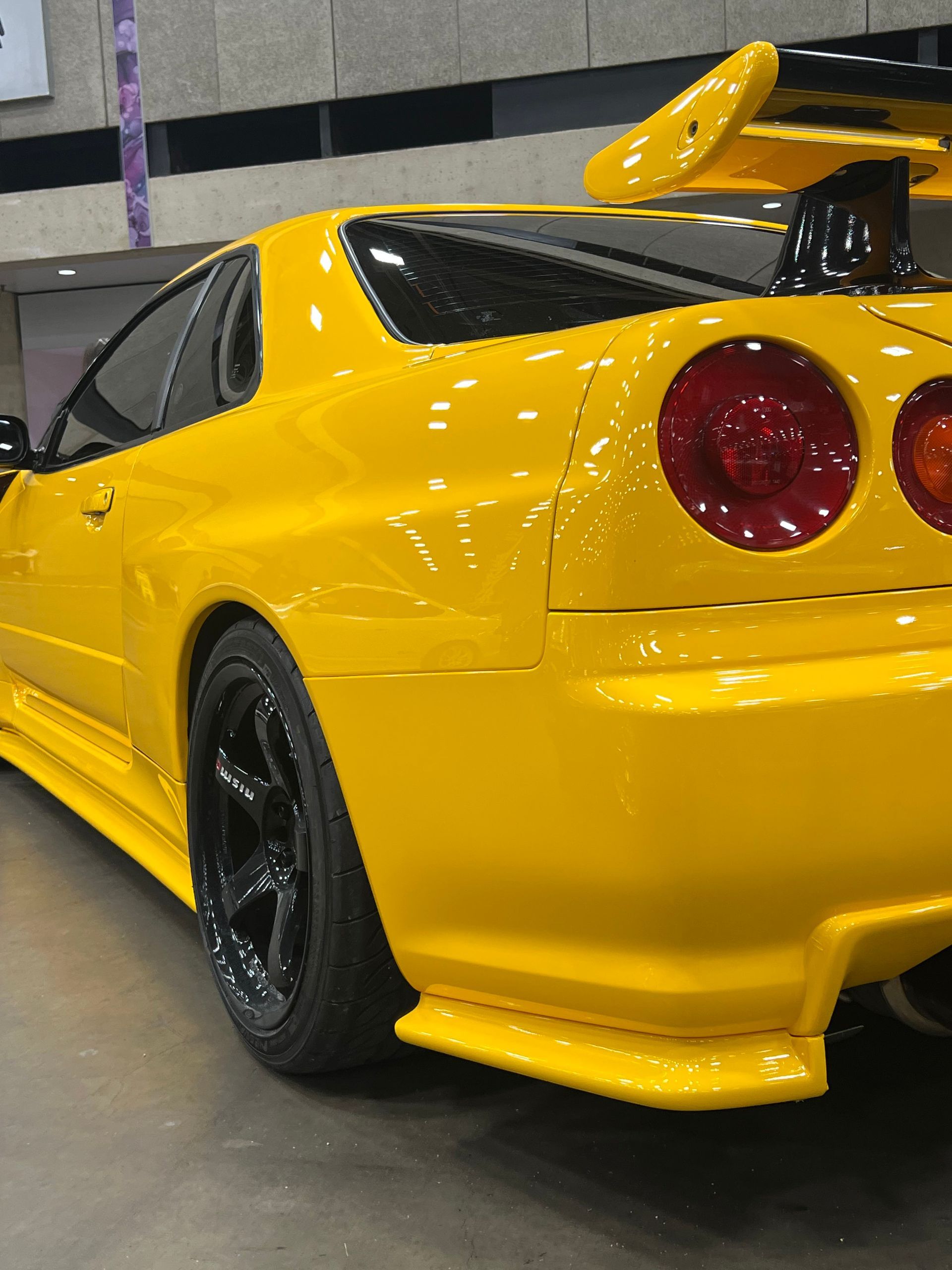 A yellow sports car is parked in a parking lot