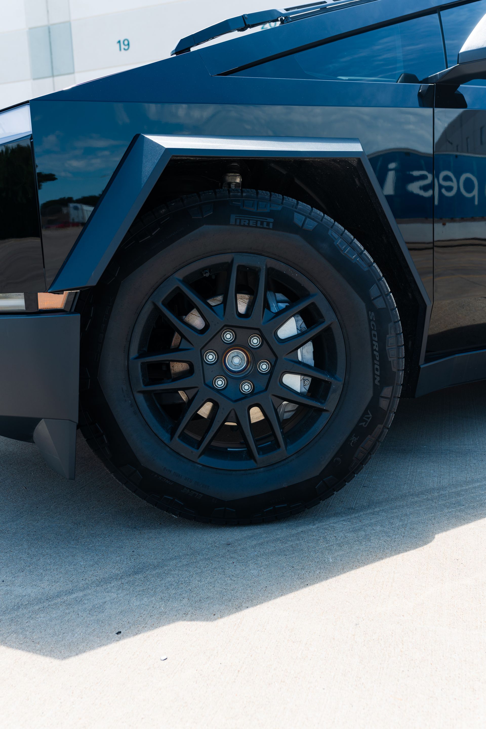 A man is working on a car window with a drill.