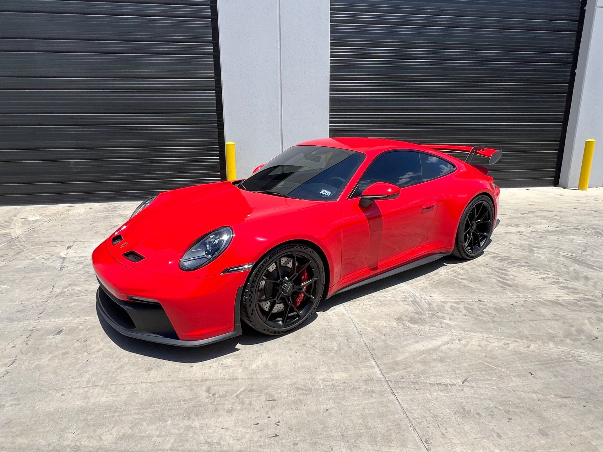 A black truck is parked in a parking lot in front of a building.