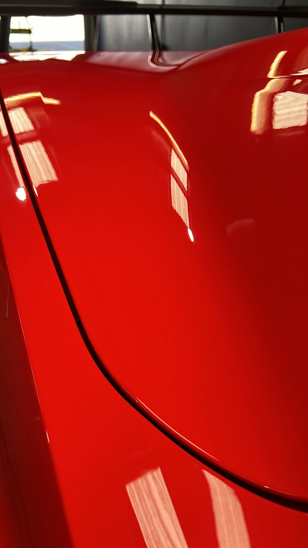 A close up of the hood of a red car