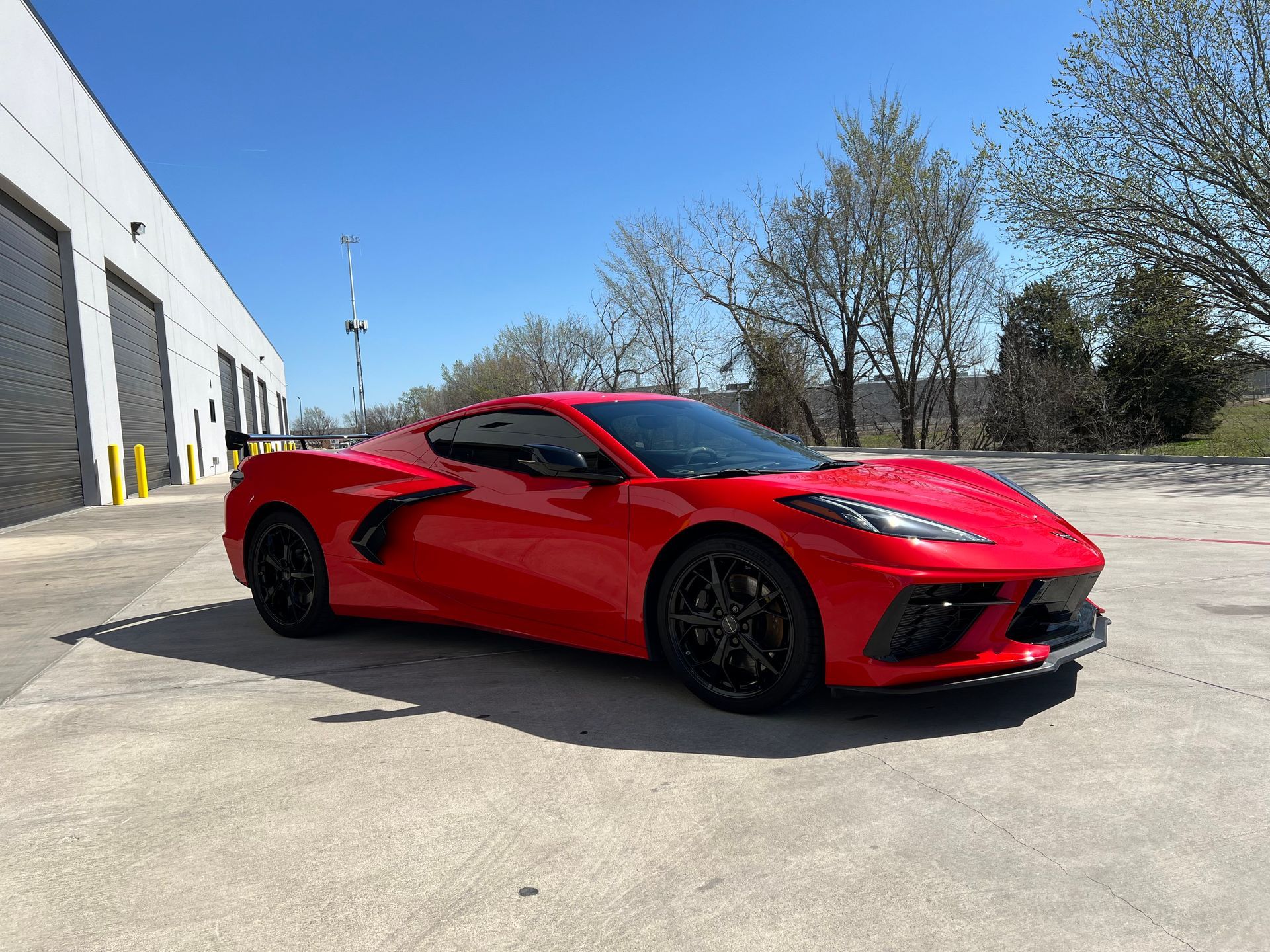 A red sports car is parked in front of a building.