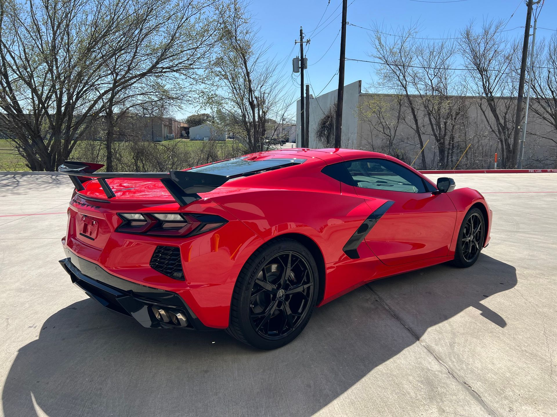 A red sports car is parked in a parking lot.