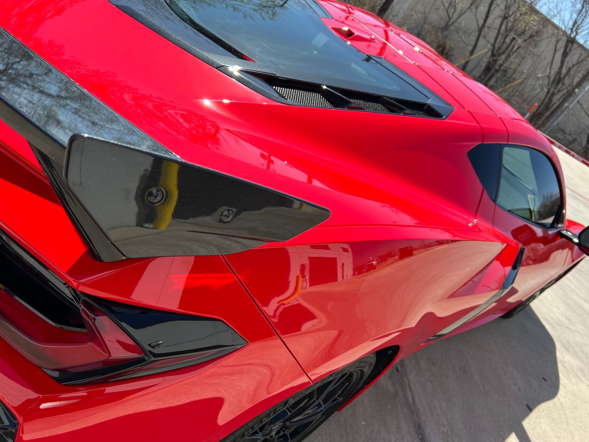 A red sports car is parked on the side of the road.