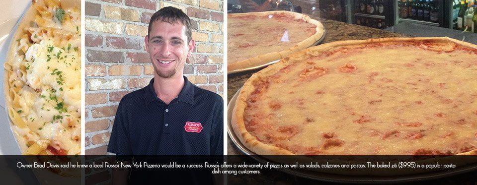 A man smiles next to pasta and two pizzas. The text reads about his restaurant.