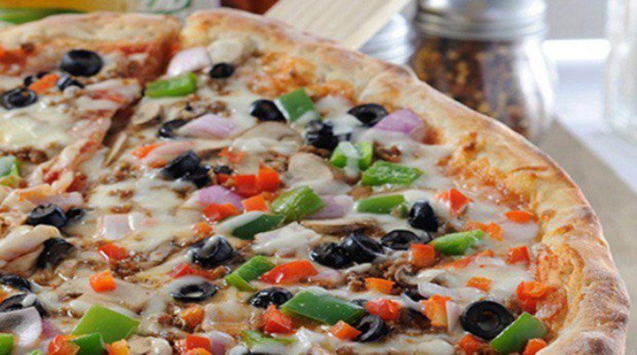 Pizza topped with black olives, green and red peppers, and red onions.