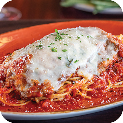 Chicken Parmesan on spaghetti in a red sauce, topped with melted cheese, served on an orange plate.