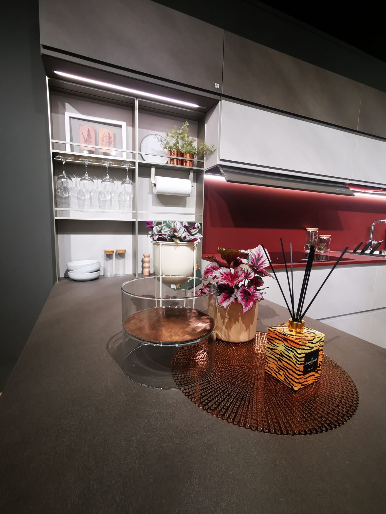 Un bancone della cucina con sopra un vaso di fiori