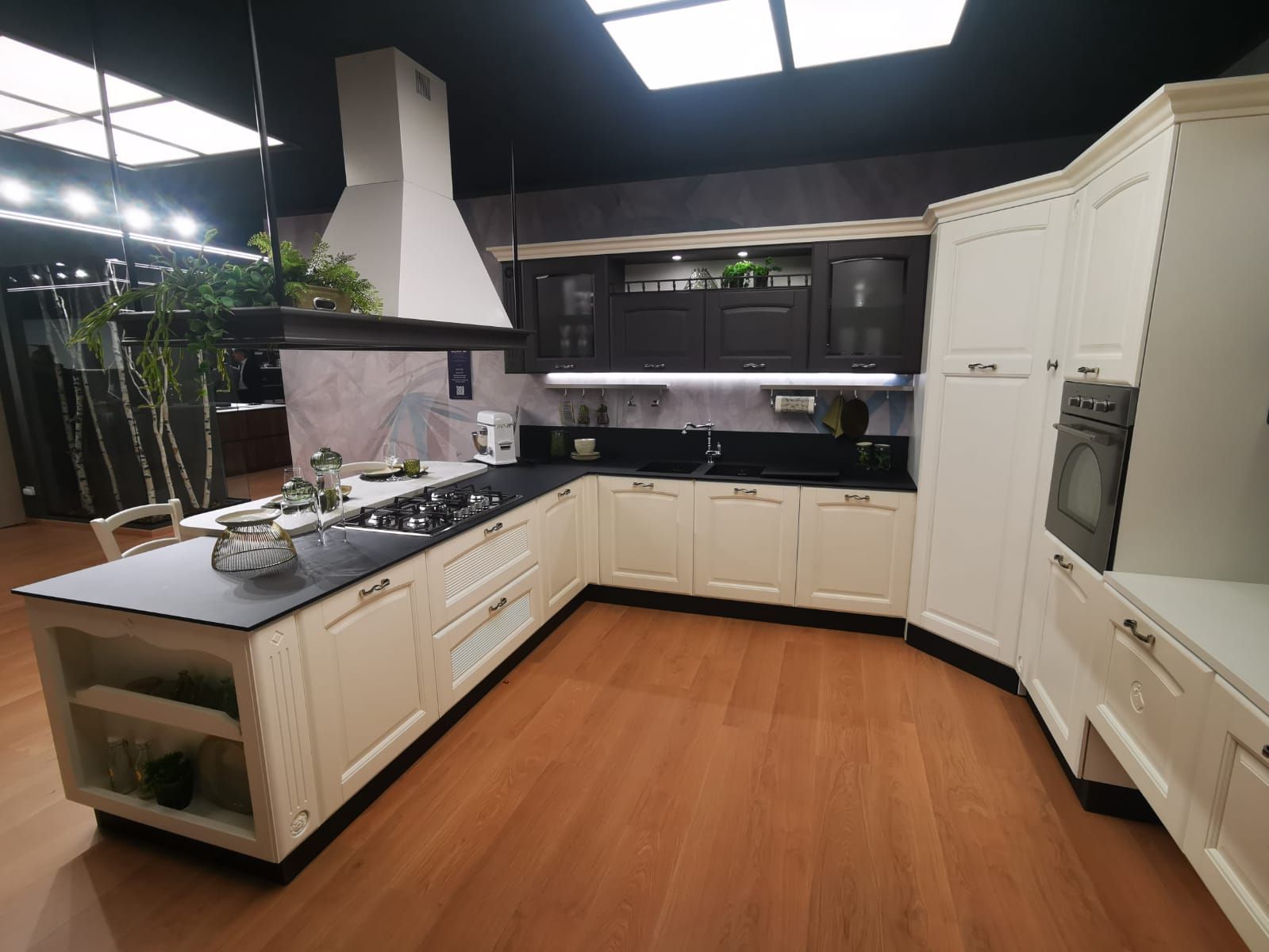 Una cucina con mobili bianchi e ripiani neri