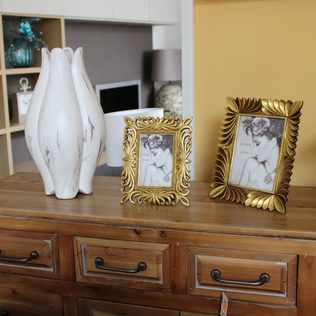 Un tavolo di legno con tre cornici e un vaso sopra