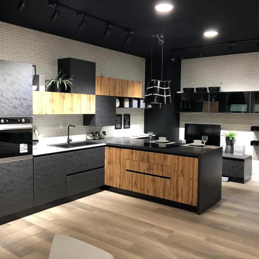 Una cucina con mobili neri e mobili in legno