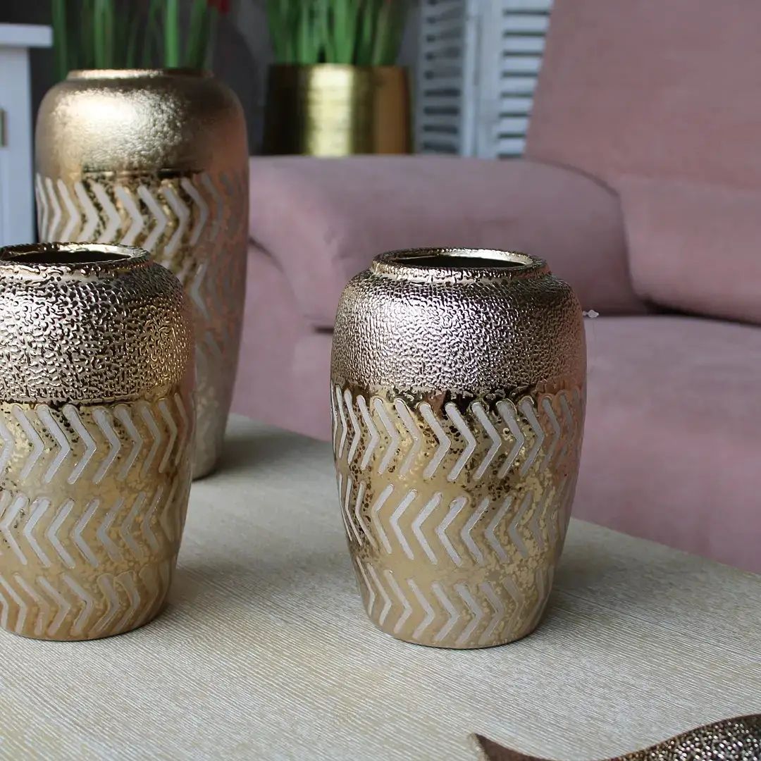 Tre vasi sono seduti su un tavolo in soggiorno.