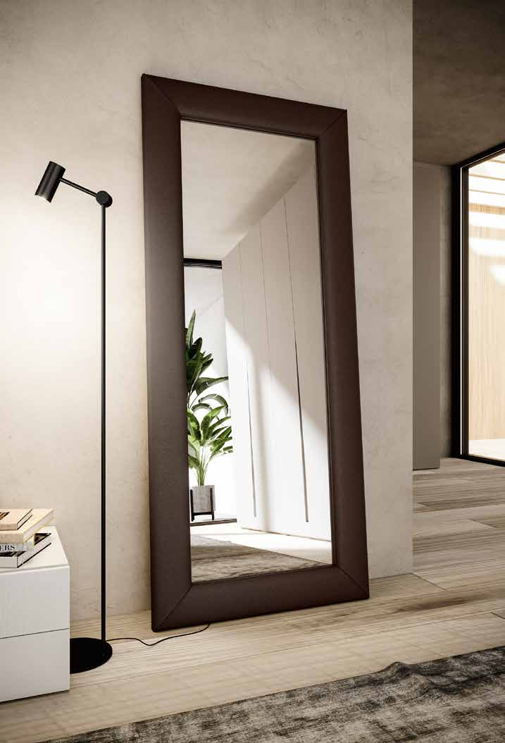 Uno specchio a figura intera è appeso a una parete in un corridoio.