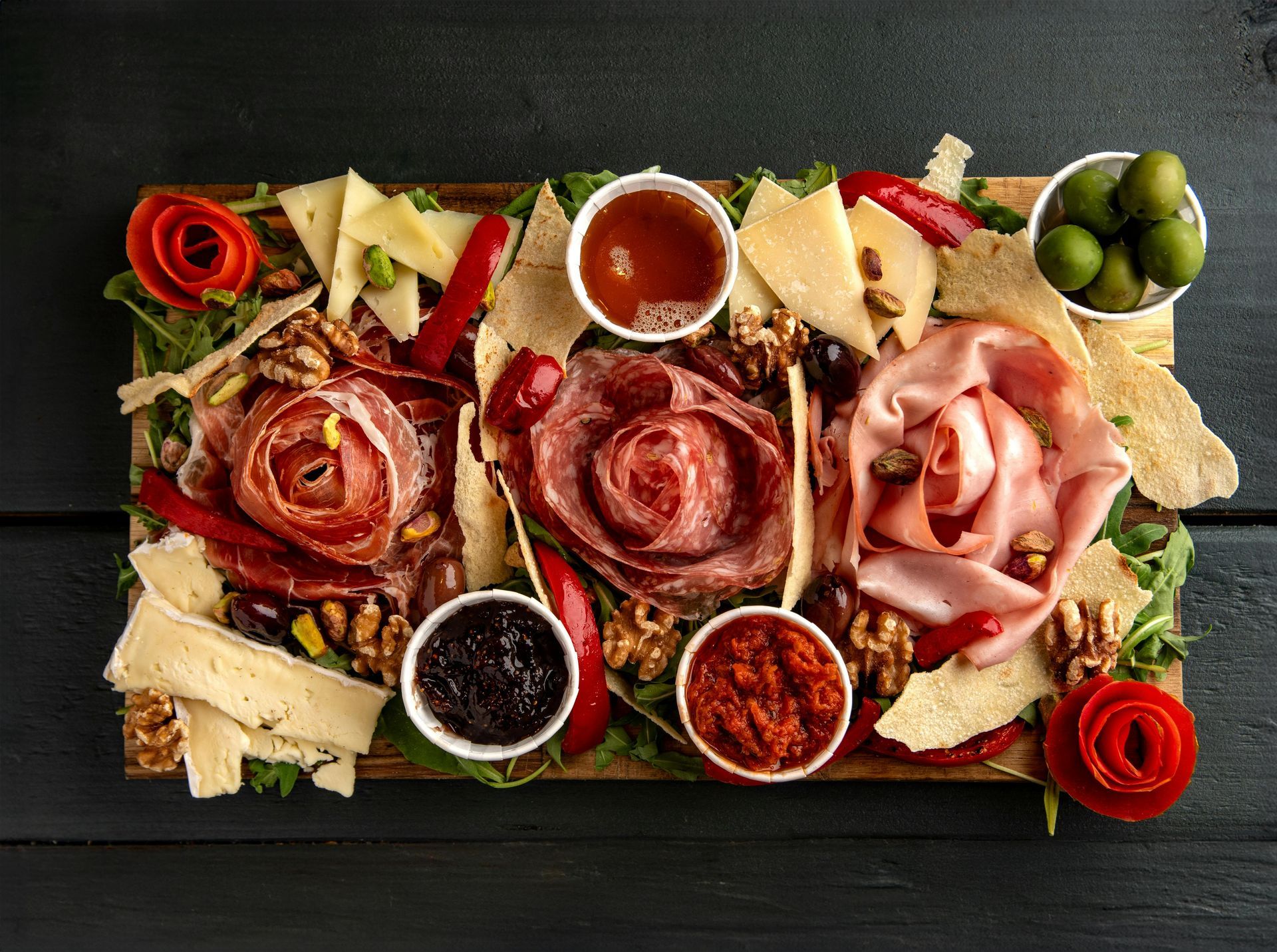 Una tabla de cortar de madera llena de muchos tipos diferentes de alimentos.