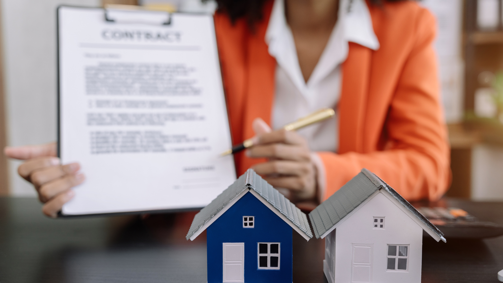 A lease agreement with two pens on a wooden table.