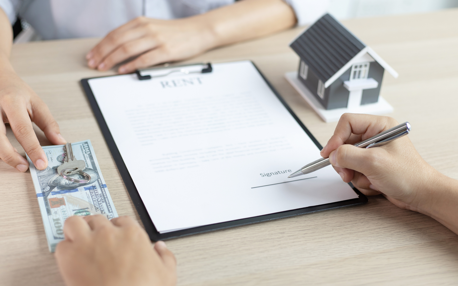 A person is giving money to another person while signing a contract.