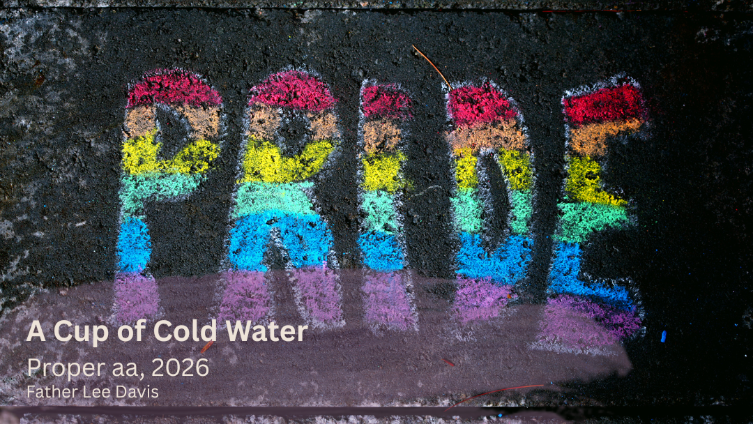 Rainbow chalk letters spelling “PRIDE” on a dark pavement, with small white text in the corner.
