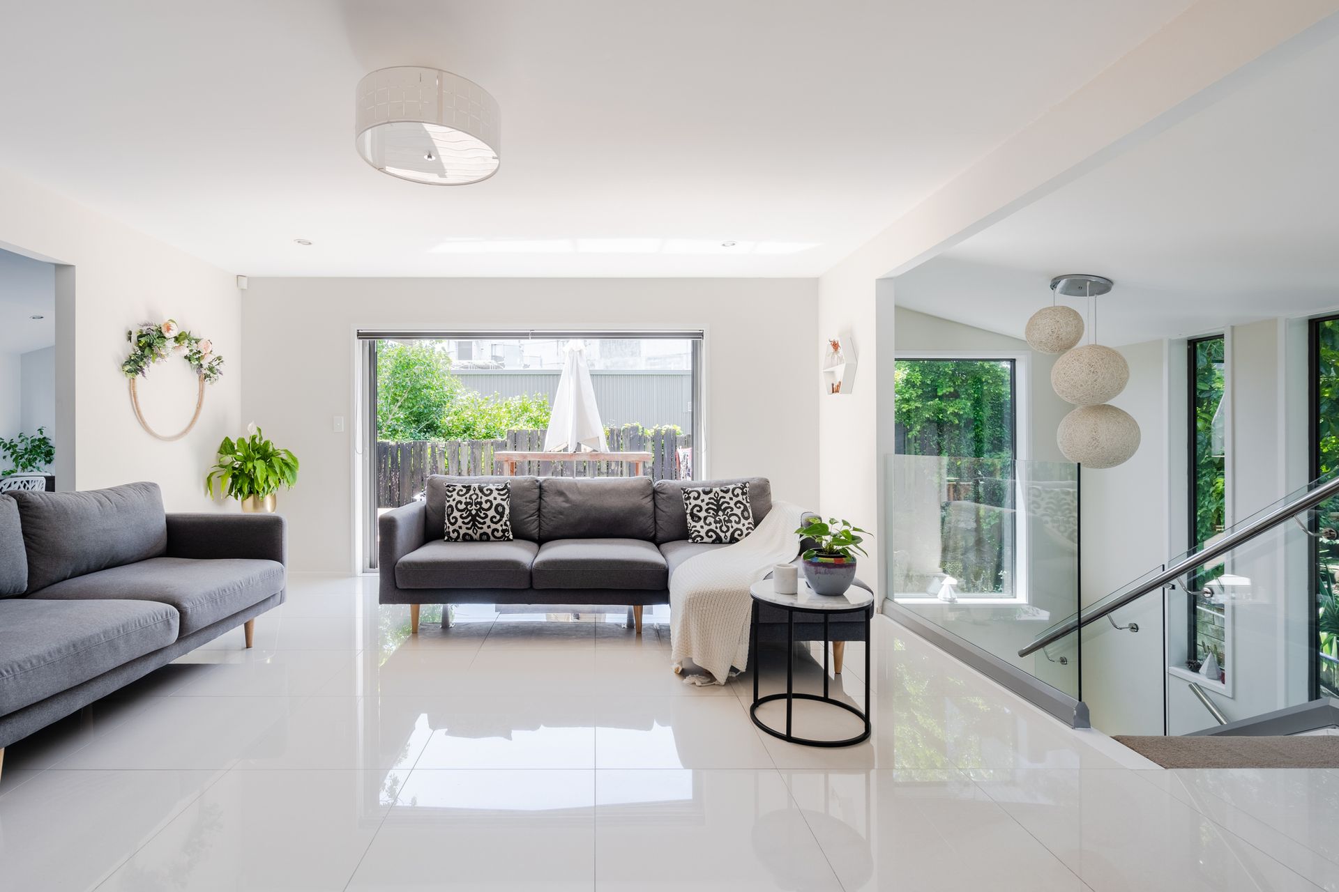 A kitchen with white cabinets , a sink , a stove , and a skylight.