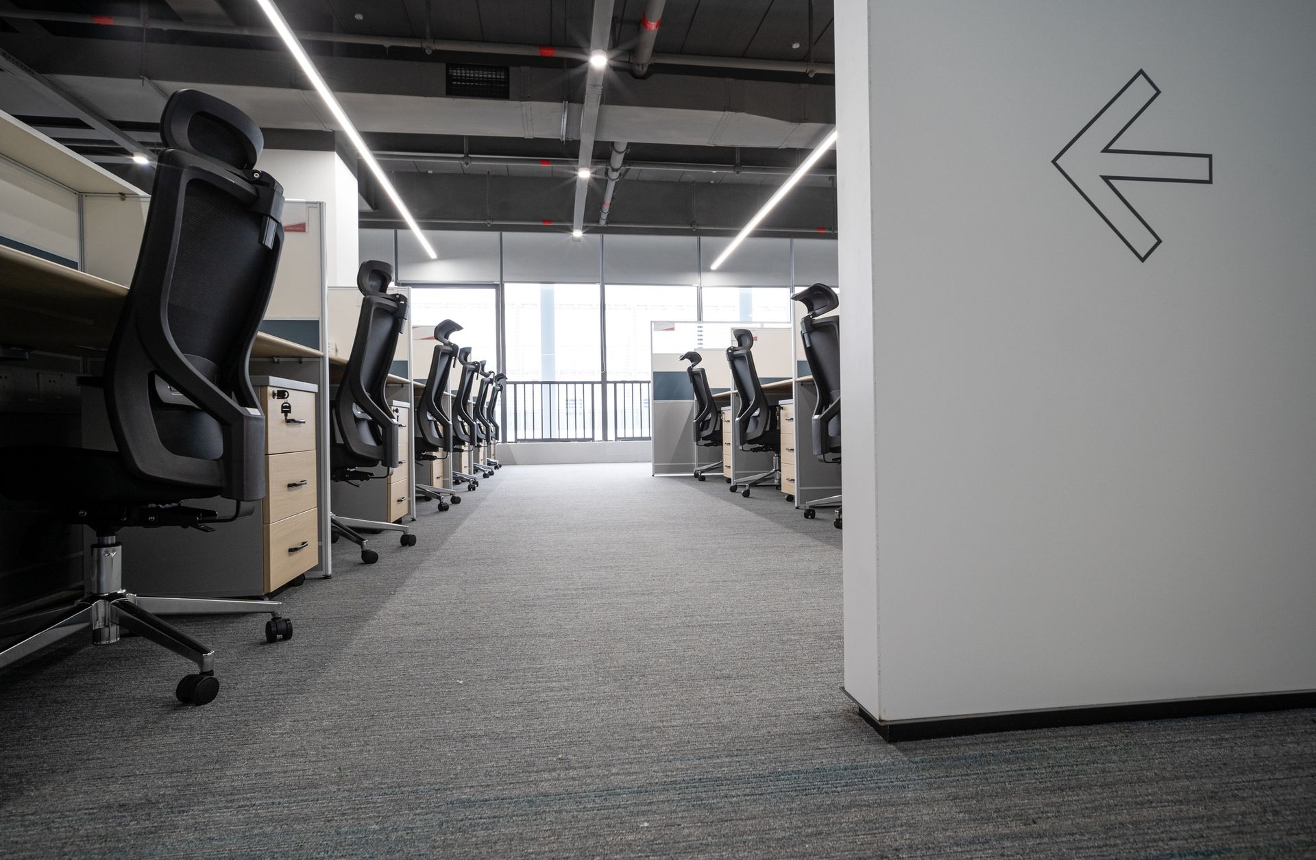 A row of office chairs is lined up in an empty office.