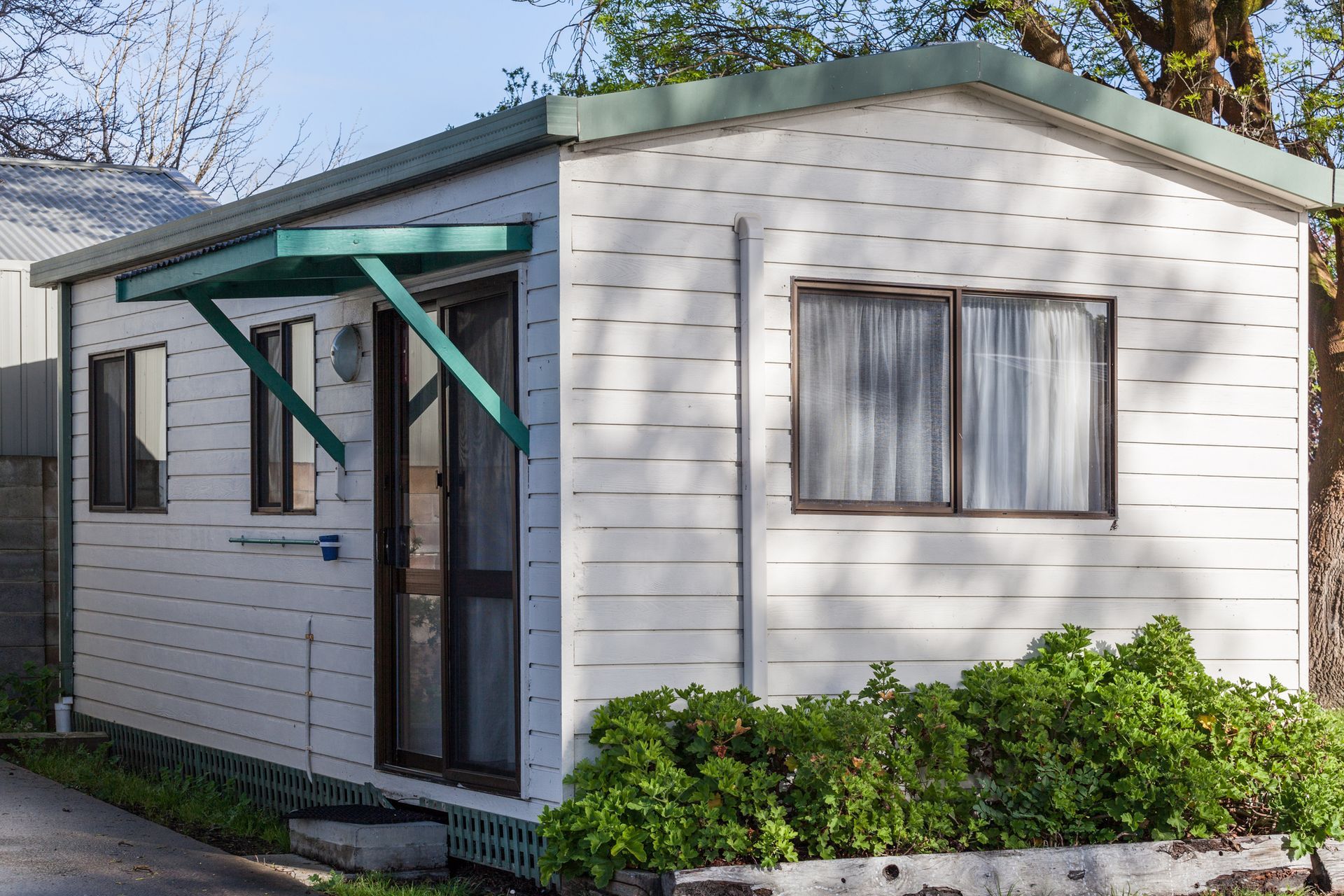 A small red and white house in the middle of a field.