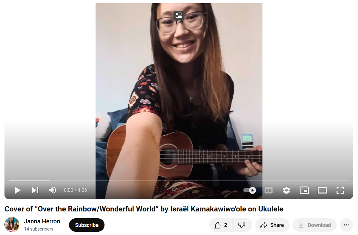 A woman is playing an ukulele in a video.