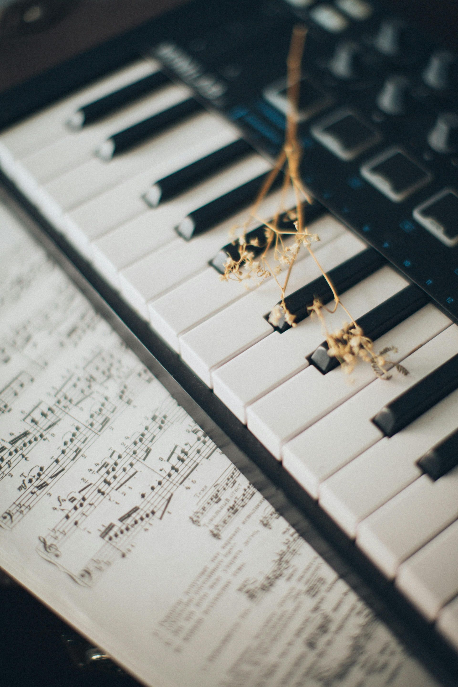 A close up of a piano keyboard and sheet music