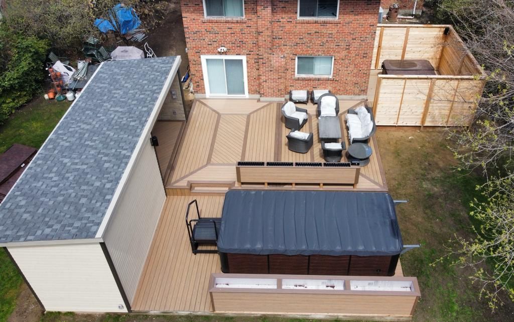 An aerial view of a backyard with a deck and a hot tub.