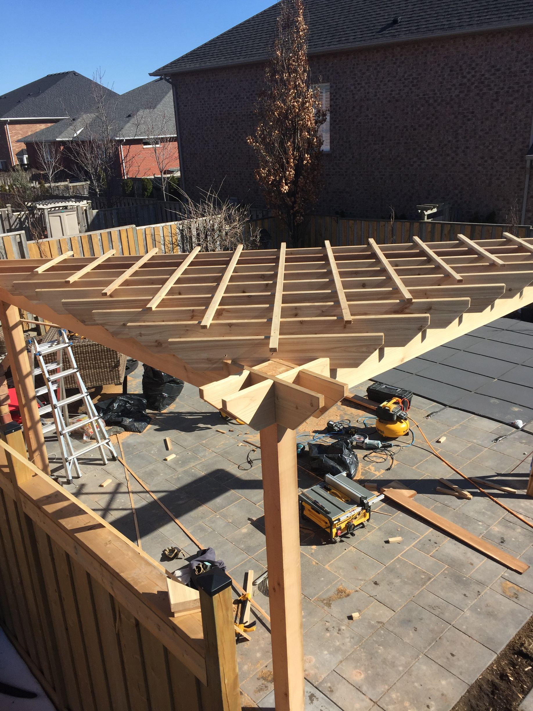 A wooden pergola is being built in front of a house.