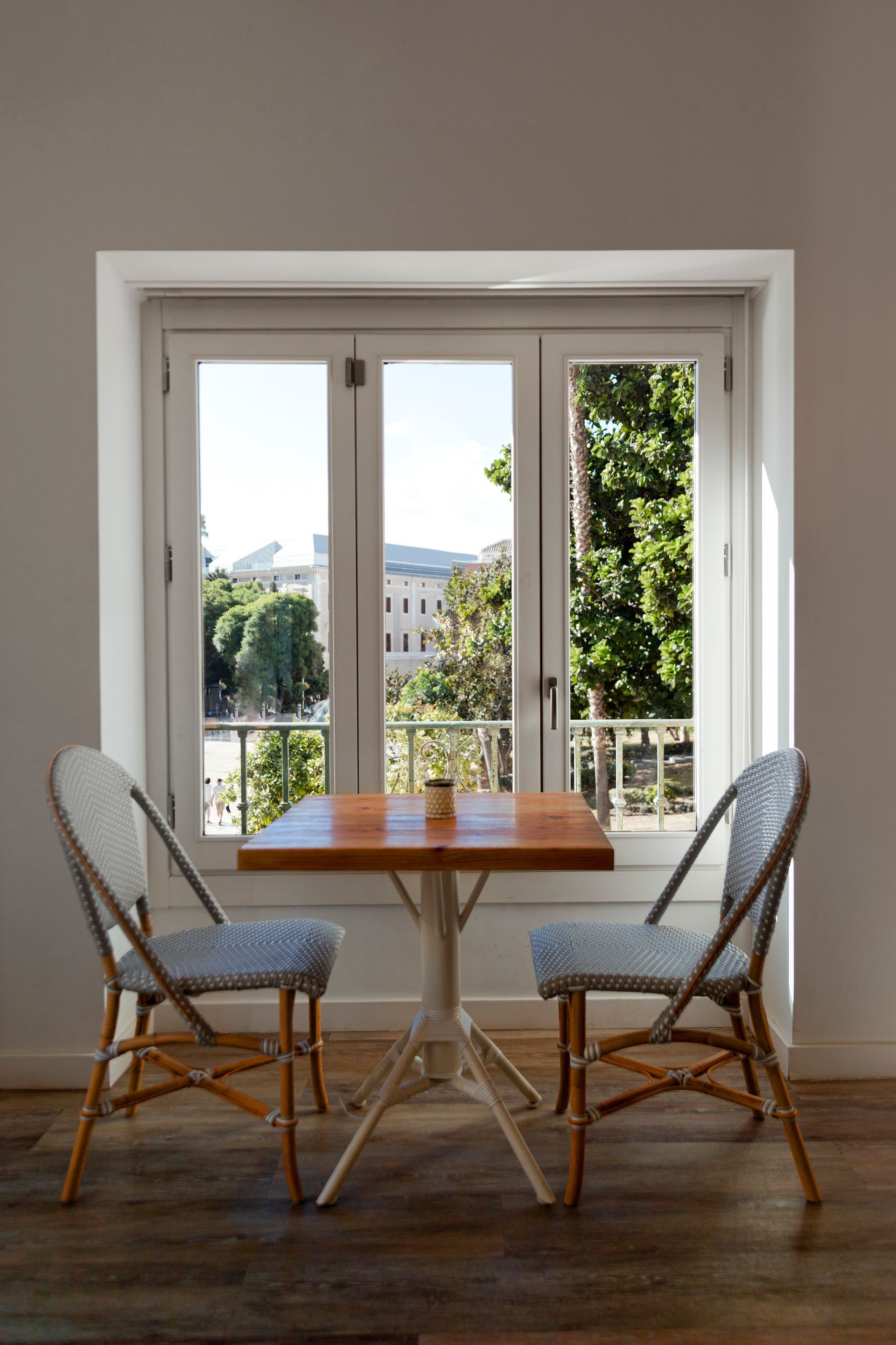 There is a table and chairs in front of a window.