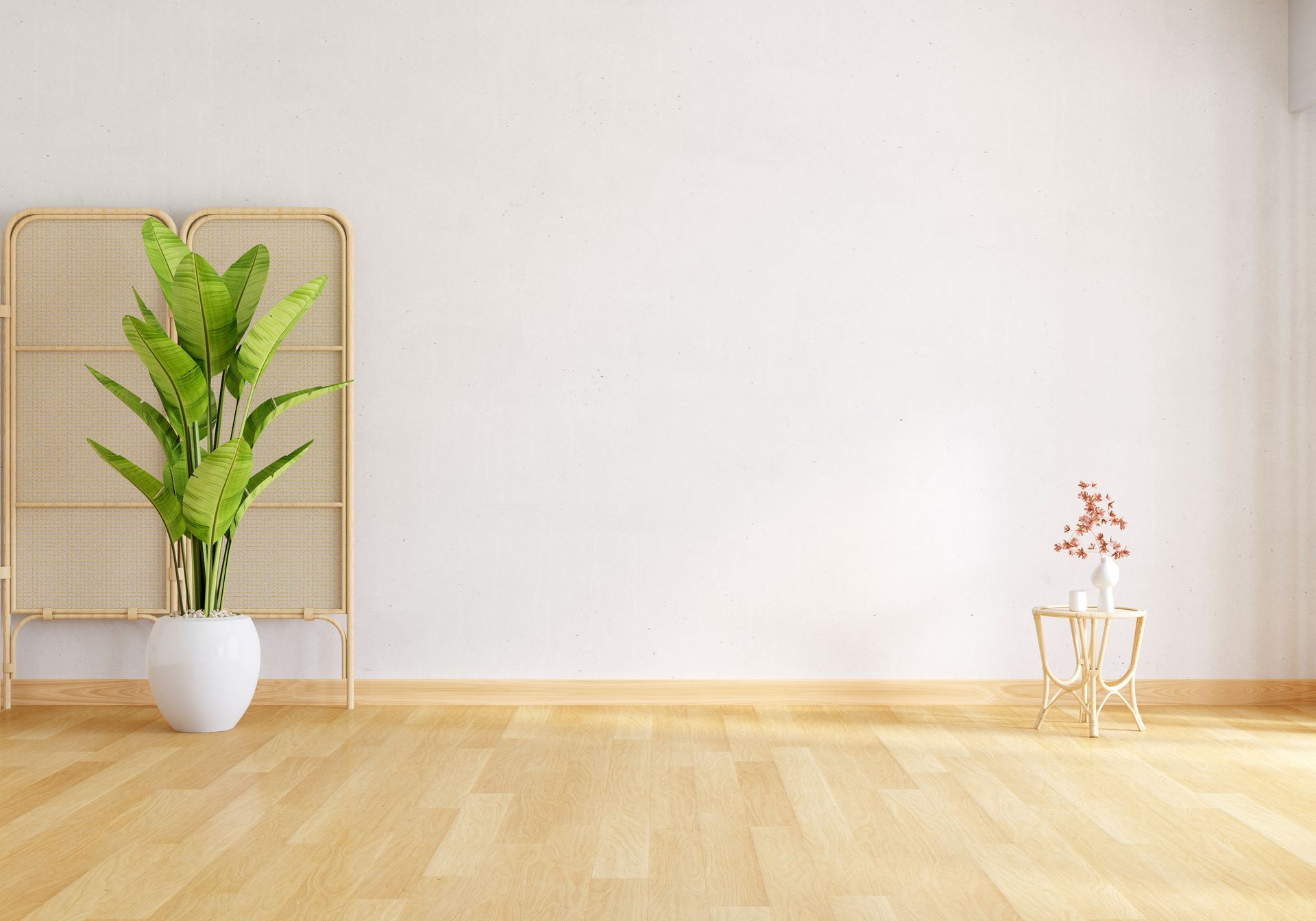 An empty room with a potted plant and a wooden table.