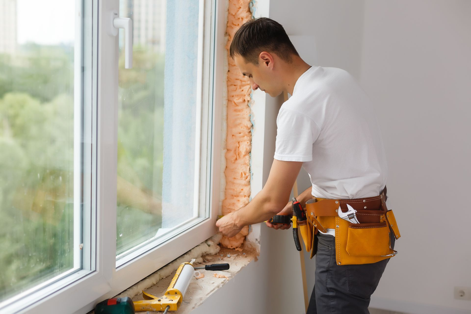 A man is installing a window in a room.