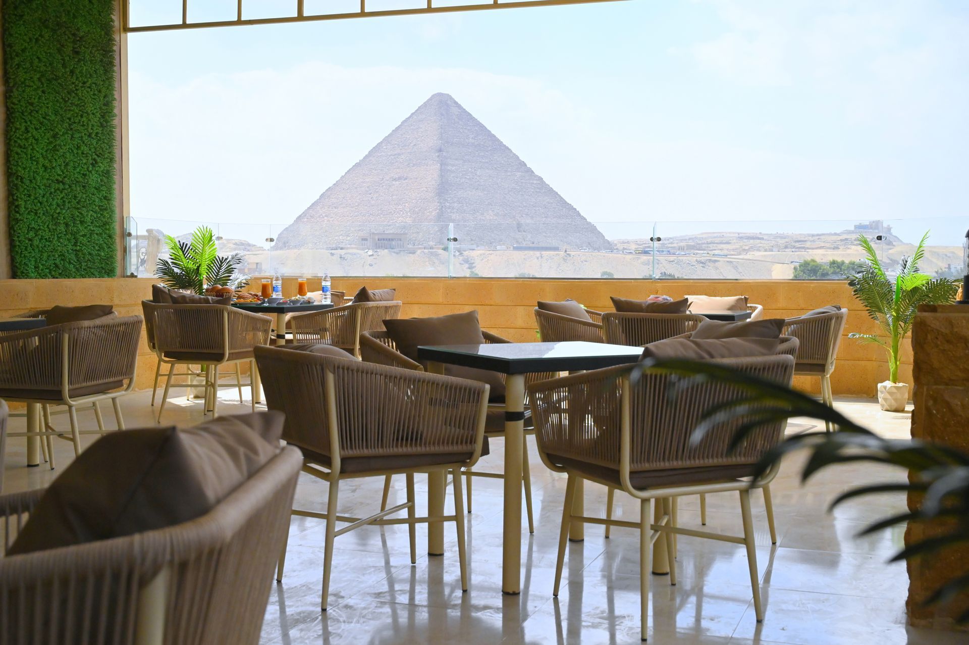 Rooftop restaurant with seating overlooking the Great Pyramid of Giza in Egypt.