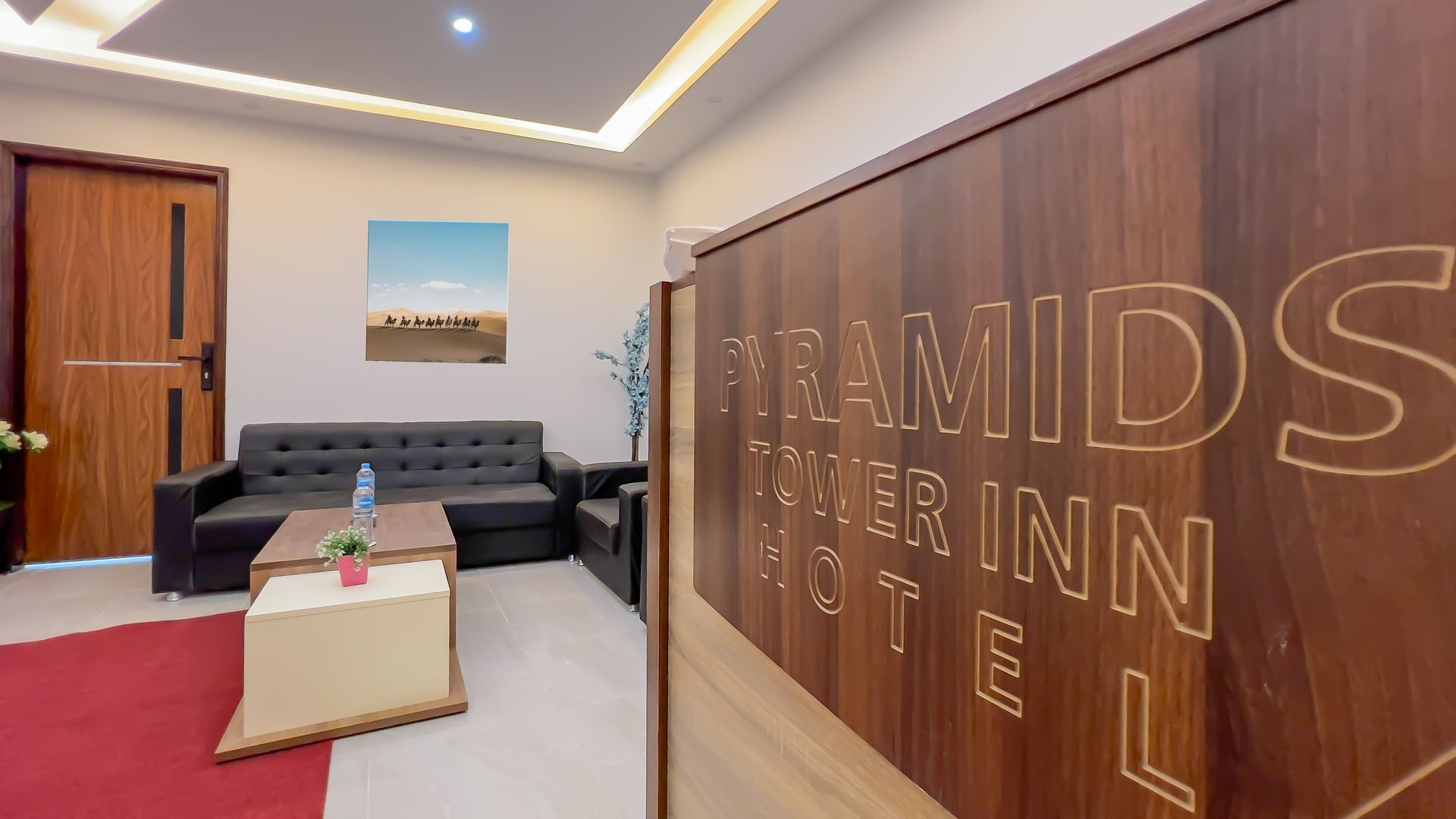 Interior of Pyramids Tower Inn Hotel, with lobby, sofa, and sign.
