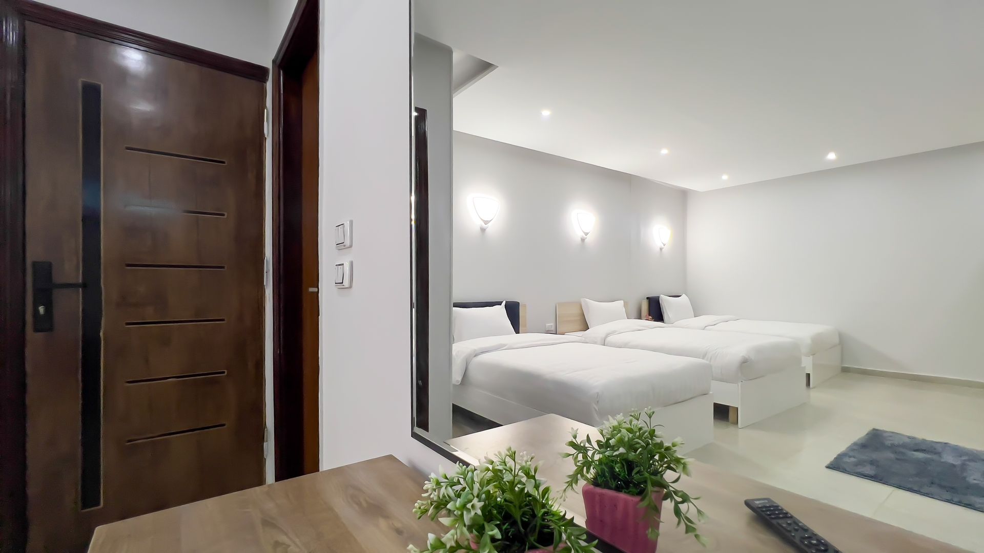 Bedroom with two beds, white linens, and wooden door.