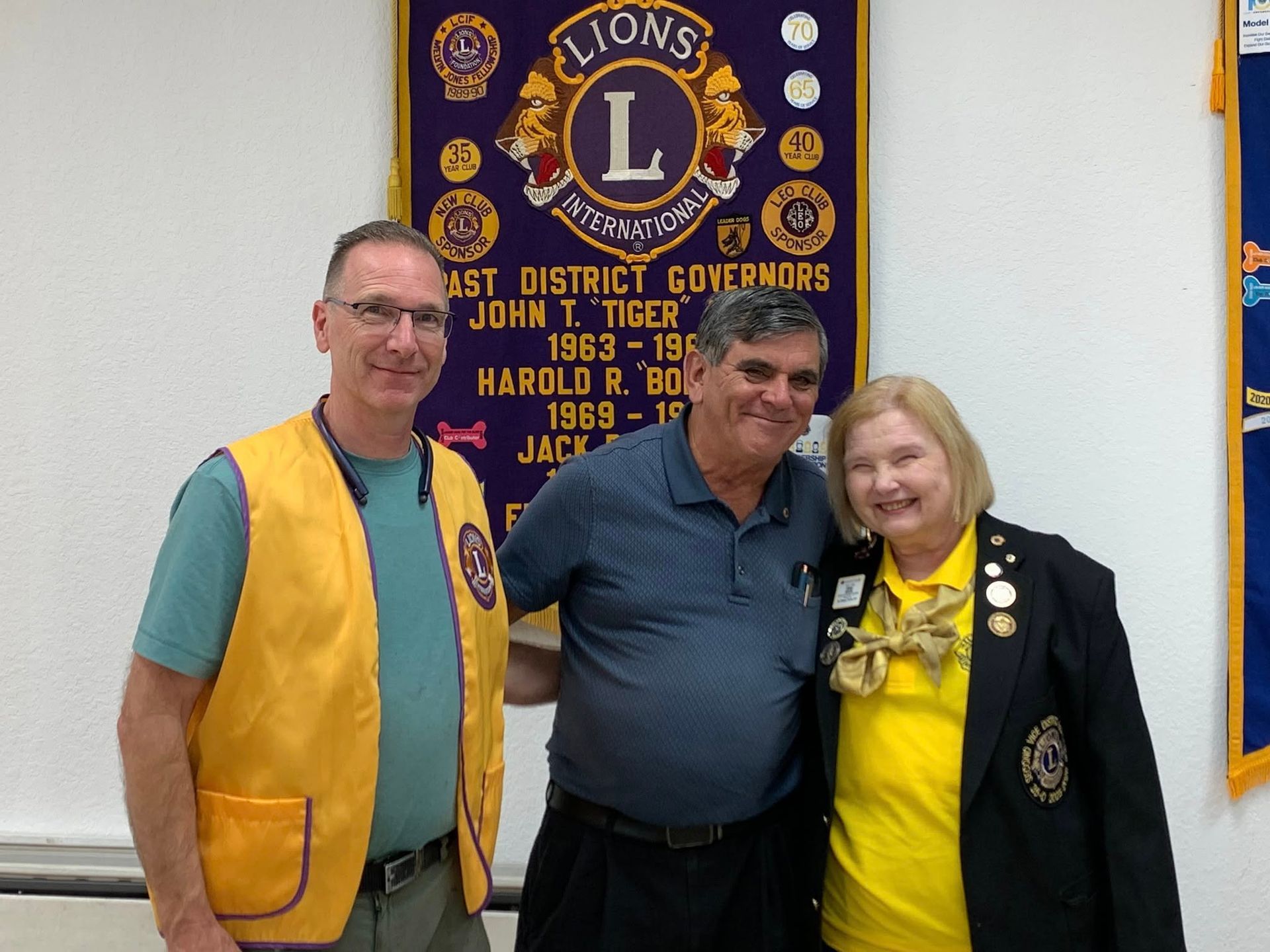 A woman wearing a mask is holding a piece of paper next to a woman in a yellow jacket.