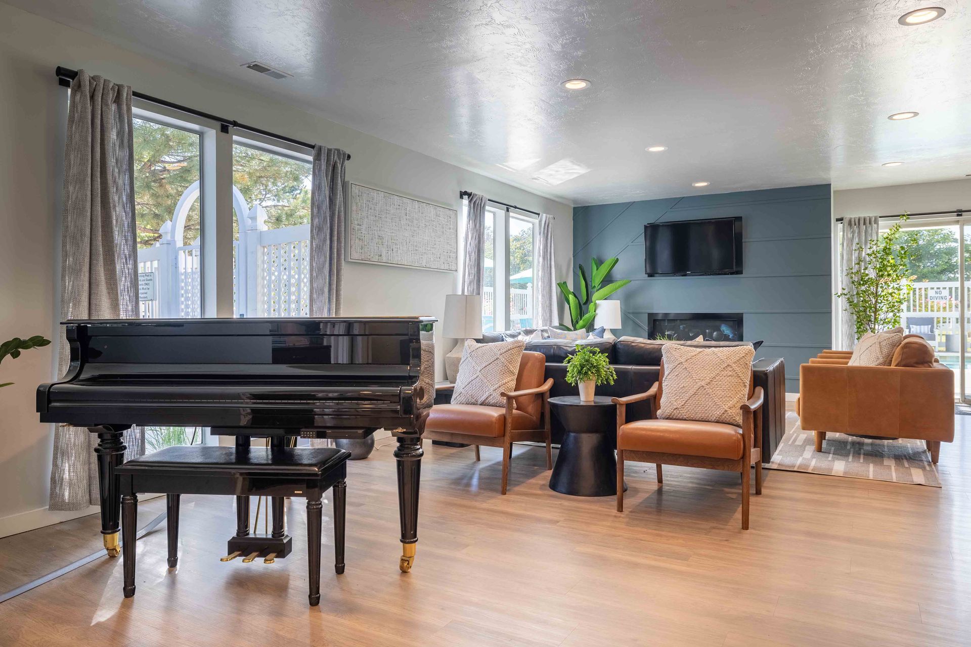 Grand piano in modern living room with seating area and fireplace.