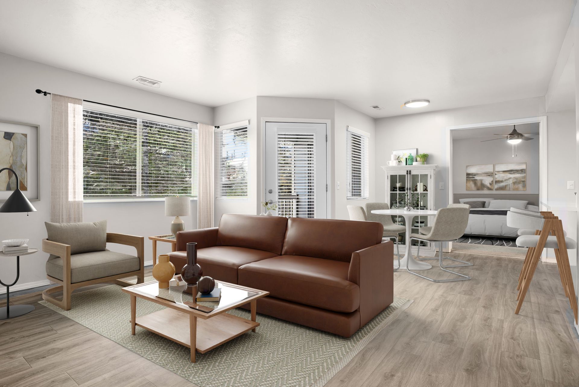 Living room with brown leather sofa, wood armchairs, and small coffee table.